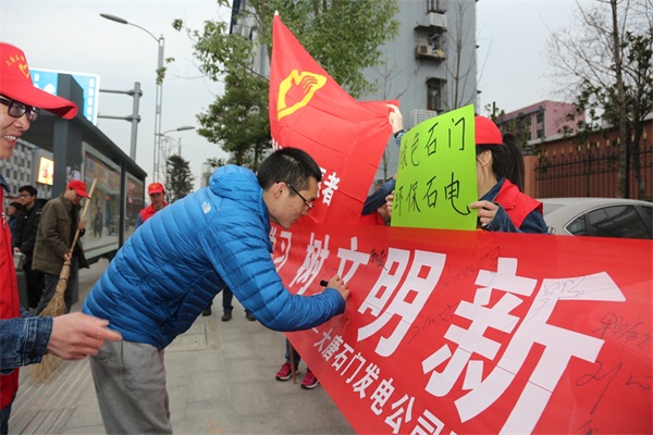 志愿者邀请行人在横幅上签名承诺.jpg